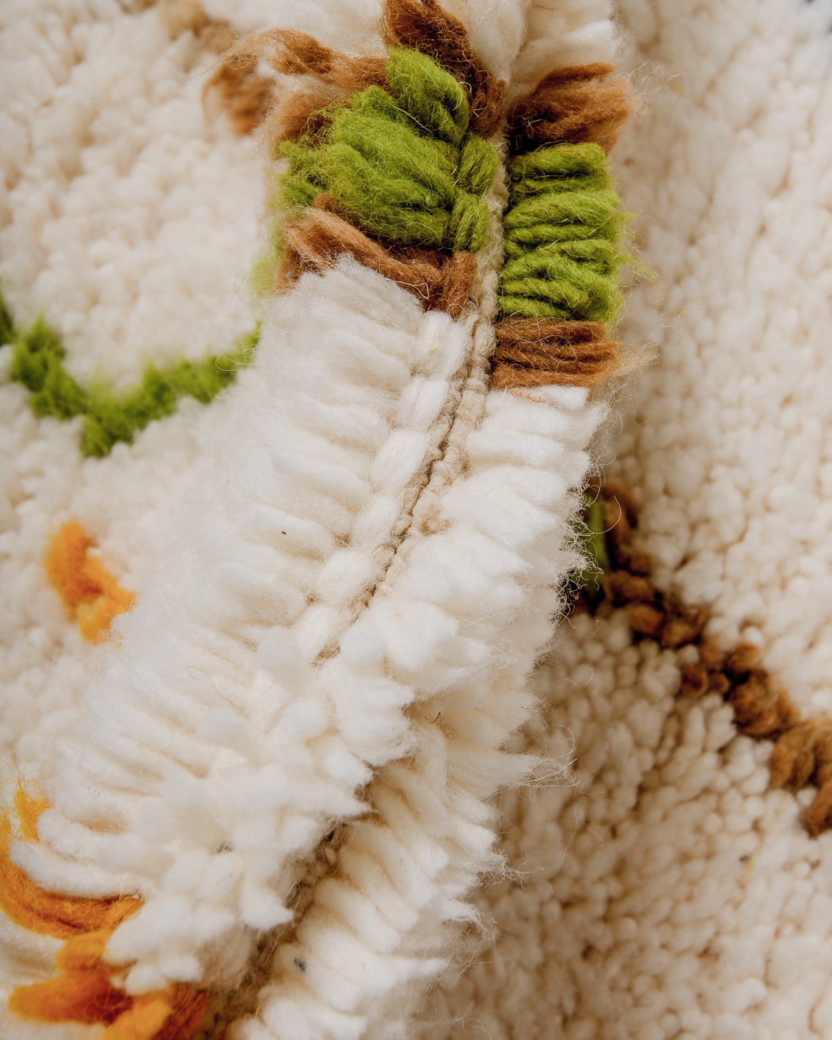 Detail of wool berber rug showing depth of pile and different coloured wool used.